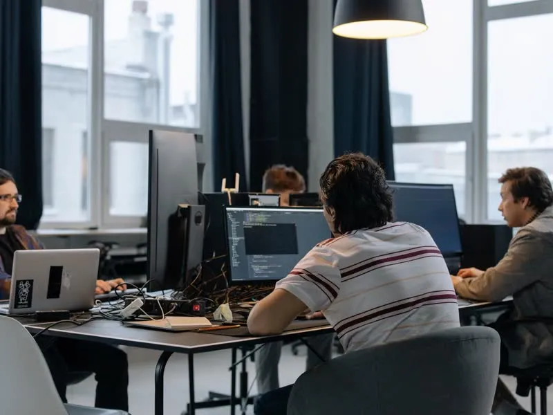 A software team working at a bank of monitors