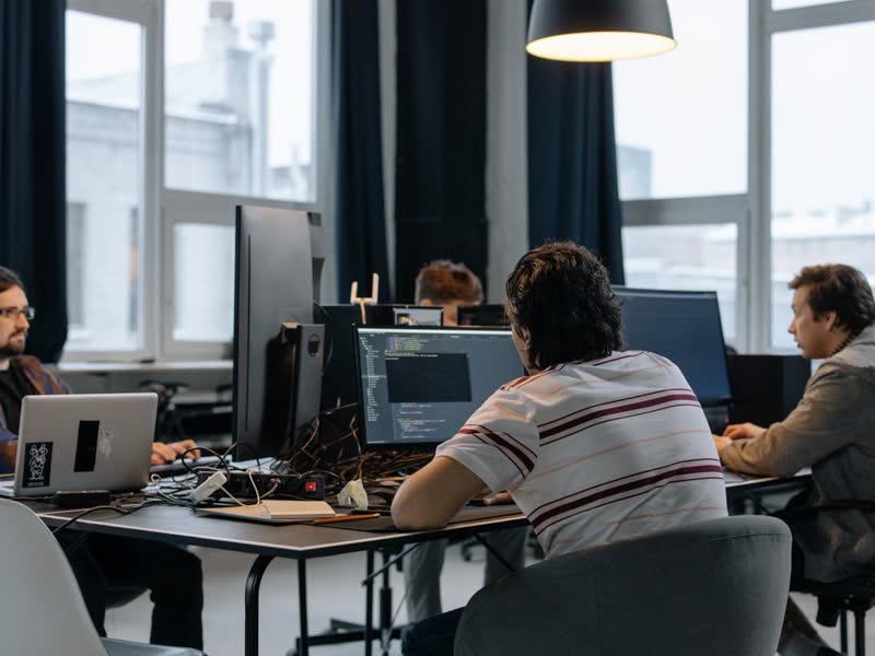 A software team working at a bank of monitors